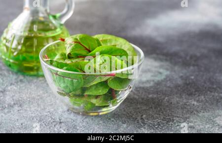 Glasschale aus rotem Chard auf grauem Hintergrund Stockfoto