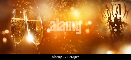Silvester Champagner mit Uhr und Feuerwerk im Hintergrund für Neujahrs-Grüße Stockfoto