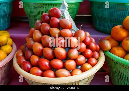 Tamarillo, Obst im Plastikkorb auf dem Straßenmarkt, Bauernmarkt in bali Indonesien Stockfoto