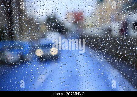 Regen auf Glas. Regen draußen Fenster auf Hintergrund der Lichter der Stadt. Tropfen Wasser fallen auf das Glas Stockfoto