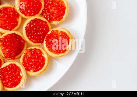 Roter Kaviar in Törtchen auf einer weißen Untertasse, Platz kopieren Stockfoto