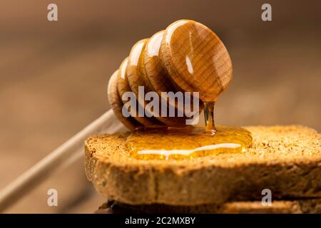 Honigwürger auf einigen Vollkornrusken auf dem Tisch. Stockfoto