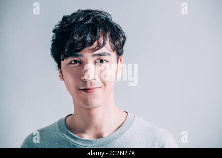 Porträt eines jungen lächelnden gutaussehenden Mannes isoliert auf grauem Hintergrund Stockfoto