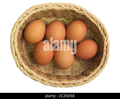 Eiern in einem Weidenkorb auf weißem Hintergrund Stockfoto