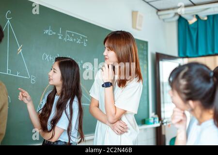 Gruppe von Studenten, die an dem mathematischen Problem arbeiten Stockfoto