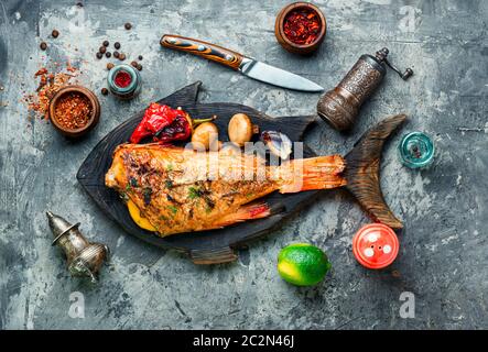 Roter Meerbarsch mit Pilzen und rotem Pfeffer gebacken.Fisch in geröstetem Gemüse Stockfoto