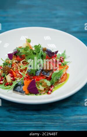 Escabeche Fischgericht mit Kaviar: Makrele in Marinade mit Gemüse, auf einem Schild auf dem Holz- blauen Hintergrund. Stockfoto