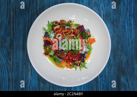 Escabeche Fischgericht mit Kaviar: Makrele in Marinade mit Gemüse, auf einem Schild auf dem Holz- blauen Hintergrund. Stockfoto