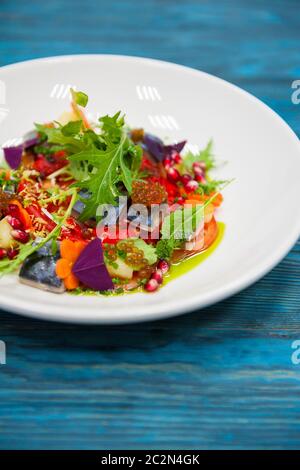 Escabeche Fischgericht mit Kaviar: Makrele in Marinade mit Gemüse, auf einem Schild auf dem Holz- blauen Hintergrund. Stockfoto