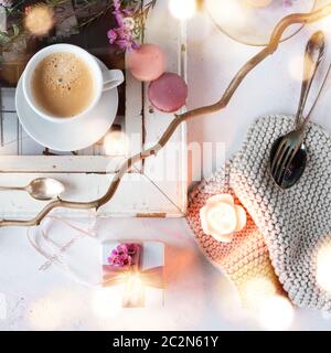 Muttertagsdeko im hellen Vintage-Stil mit Makronen und einer Tasse Kaffee. Quadratisches Blumenstilleben mit stimmungsvollem Bokeh für ein Frühstück zurück Stockfoto