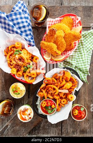 Leckere fast Food mit lockigen Pommes Frites und gebratenen Hähnchenfingern Stockfoto