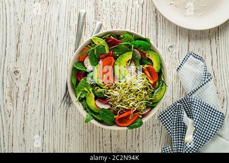 Gesunde grüne Salatmahlzeit mit Luzera-Sprossen, Avocado und Obst auf Holzgrund Stockfoto