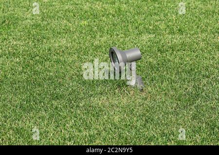 Metall, solarbetriebene Gartenlampe auf einem Hintergrund von grünem Rasen Stockfoto