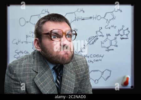 Bizarre Professor in Brille über chemische Formeln denken Stockfoto