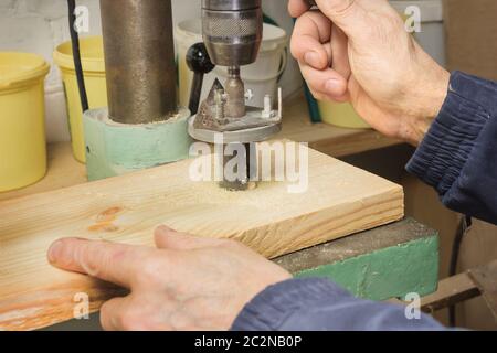 Zimmermann bohrt ein Loch in das Brett Stockfoto