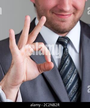 Porträt des Lächelns Geschäftsmann zeigt OK Sign. Stockfoto