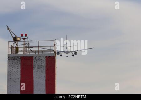 Flugzeug landet auf dem Flughafen über dem Gebäude mit Lichtern Stockfoto