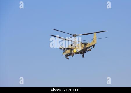 Grüne Hubschrauber fliegt gegen den blauen Himmel Stockfoto