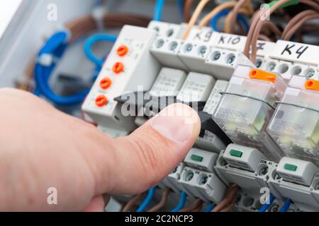 Hand eines Elektrikers Einschalten ein Sicherungskasten Stockfoto