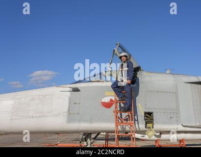 Militärpilot im Helm steht in der Nähe von Jet-Flugzeug Stockfoto