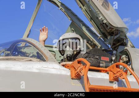 Militärischer Pilot im Cockpit Jet Flugzeug mit erhobener hand Stockfoto