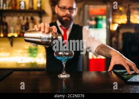 Barkeeper mit Shaker macht Alkohol cocktail hinter einer Bar Theke Stockfoto