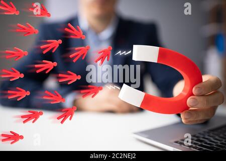 Unternehmer zieht Team Blau mit Hufeisen Magnet Stockfoto