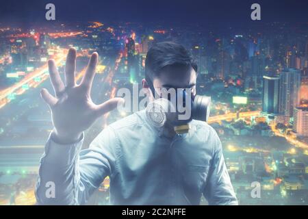 Junger Mann in Gasmaske in der Nachtstadt Stockfoto
