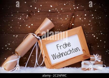 Rahmen mit Deutschen Kalligraphie Frohe Weihnachten bedeutet, frohe Weihnachten. Weihnachtsdekoration wie Gabe und Gegenwart. Holz- Hintergrund mit Schnee und Sno Stockfoto