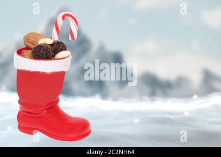 Weihnachtskarte Vorlage. Ein roter Weihnachtsmann Stiefel mit Nüssen und anderen Süßigkeiten vor einer abstrakten verschwommenen Winter weihnachtslandschaft mit m gefüllt Stockfoto