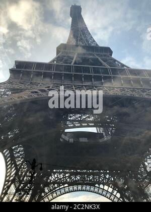 Ein Blick auf den Eiffelturm mit der Spiegelung durch die Glaswand bei bewölktem Tag, Paris, Frankreich Stockfoto