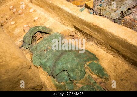 Archäologische Ausgrabungen der menschlichen Mumie in einem grünen Lappen eingewickelt. Stockfoto