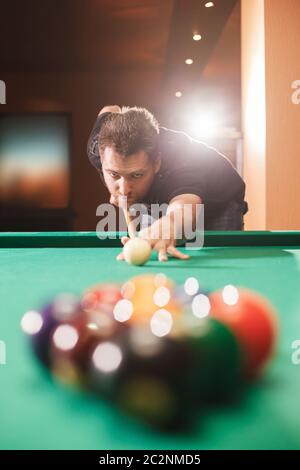 Spieler bricht eine Pyramide in Billard. Nachtleben. Billardzimmer im Hintergrund. Stockfoto