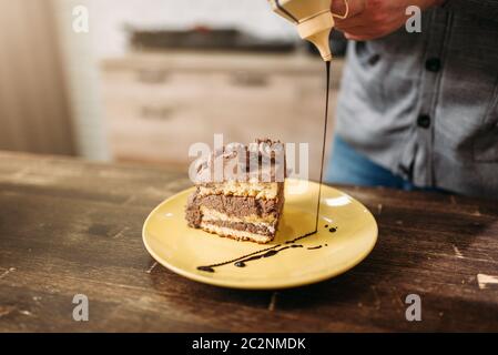 Stück Kuchen auf dem Teller, Dekoration mit Schokoladensauce. Hausgemachte Desserts, kulinarisches Meisterwerk Stockfoto
