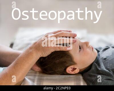 Osteopathie Behandlung und Wort Osteopathie. Die Elementare alter Junge Stirn von echten osteopathischen Arzt manipuliert Stockfoto