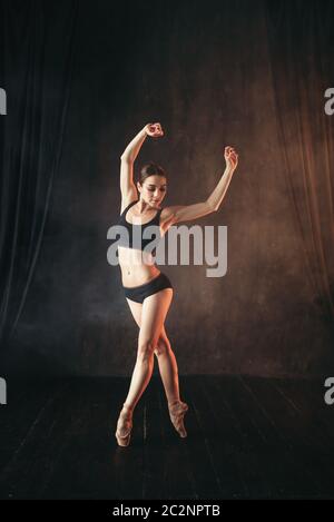 Klassisches Ballett Tänzerin in schwarz Praxis Ausbildung auf der Bühne. Anmutige Ballerina posiert im Studio Stockfoto