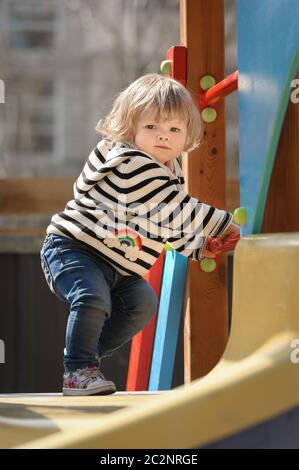 Niedliches kleines Kleinkind Mädchen fast rutscht die Kinderrutsche Stockfoto