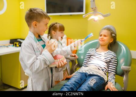 Kinder in Uniform spielen Zahnarzt Arzt, Spielzimmer. Kinder spielt Medizin Arbeiter in imaginären Krankenhaus, stomatologist Beruf lernen, kindliche dr Stockfoto