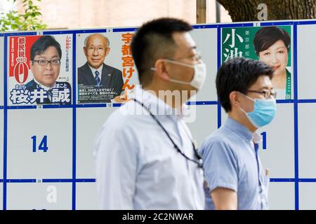 Fußgänger kommen an einem Plakatbrett vorbei, das mit den Plakaten der Kandidaten für die bevorstehenden Gouverneurswahlen in Tokio vor dem Hibiya Park am 18. Juni 2020 in Tokio, Japan, aufgestellt wurde. Die Kampagne begann offiziell am Donnerstag, 18. Juni, und wird am 5. Juli stattfinden. Quelle: Rodrigo Reyes Marin/AFLO/Alamy Live News Stockfoto