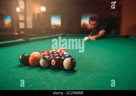 Spieler bricht eine Pyramide in Billard. Nachtleben. Billardzimmer im Hintergrund. Stockfoto