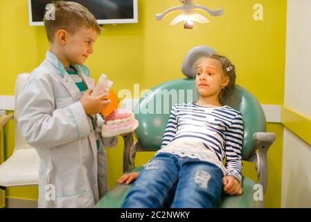 Kleiner Junge in Uniform, der Zahnarztpraxis, Spielzimmer spielt. Kinder spielt Mediziner in imaginären Krankenhaus, Stomatologe Beruf Lernen, kindisch Stockfoto