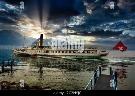 Eleganter Raddampfer (La Suisse), der den Genfer See mit atemberaubenden Wolken und Bergen im Hintergrund navigiert, Schweiz Stockfoto
