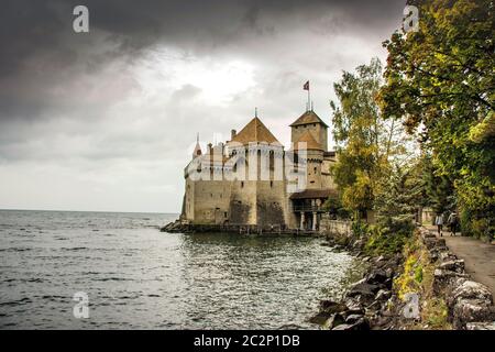 Erkunden Sie Castle Chillon mit dramatischem Himmel am Lake Leman in Montreux, Kanton Waadt, Schweiz Stockfoto