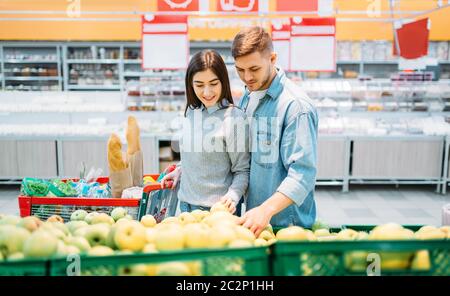 Paar mit Warenkorb Sie frische Äpfel im Supermarkt, Familie einkaufen. Kunden im Shop, Einkäufer im Markt Stockfoto