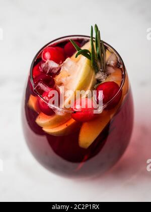 Winter Sangria auf der Tischplatte mit grau Leinen Tischdecke. Gläser Sangria mit Obst schneiden, Cranberry und Rosmarin. Vertikale. Stockfoto