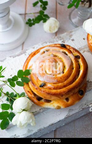 Zimt-Brötchen mit Rosinen, Vintage und Shabby-Stil, vertikale Bild verwirbelt Stockfoto