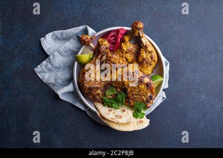 Tandoori Huhn in Tikka mariniert serviert mit Reis Naan, Limette und Koriander. Indische Küche, Tikka-Vorspeise. Blauer Hintergrund mit Kopierbereich Stockfoto