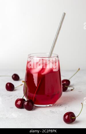 Cocktail mit süßer Kirsche und Eis auf hellem Hintergrund Stockfoto