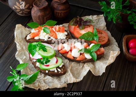 Verschiedene Bruschetta mit verschiedenen Belägen. Appetitliche Bruschetta oder Sandwiches. Mischen Stockfoto