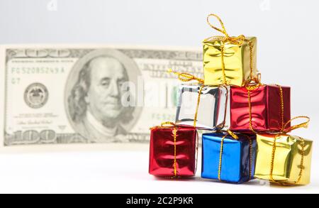 Kleine Weihnachtsgeschenke mit Rechnung $100 auf Hintergrund Stockfoto